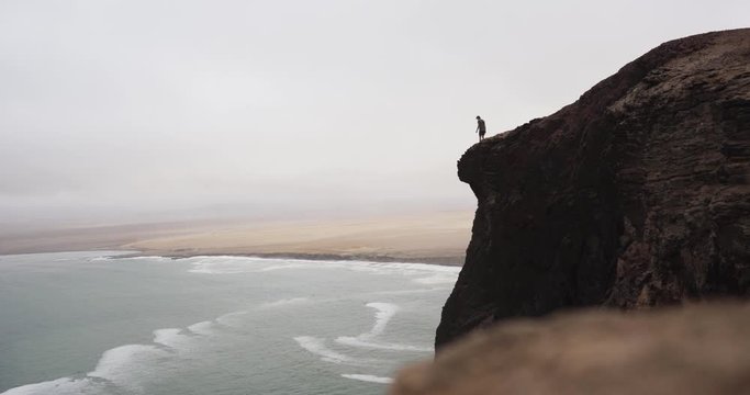 A person walking close to a beautiful natural cliff near Paracas in Peru.