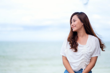 Fototapeta na wymiar A beautiful asian woman sitting by the sea