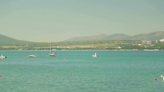 Small sailboats and yachts sail in the sea.