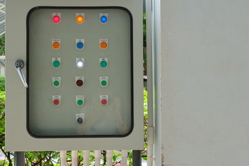 Closeup control panel lamps behind the blurred glass cover of switchboard, focus on white lamp with the word low, keep low profile concept, also can see reflection of photographer in the glass 