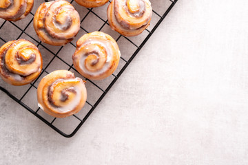 Homemade baked cinnamon rolls on cooling on cooling rack