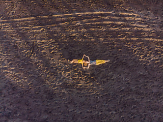 Mom and son are lying on the sand at sunset. View from the drone. Paradise, travel, vacation concept