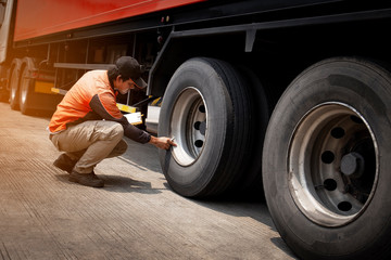 Fototapeta na wymiar Asian Truck Driver is Checking the Truck's Safety Maintenance Checklist. Inspection Truck Safety of Semi Truck Wheels Tires. Auto Service Shop. 