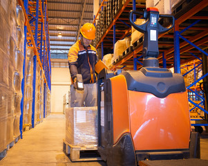 Workers Working with Electric Forklift Pallet Jack. Warehouse Inventory Management Packaging Boxes in Warehouse. Shelf Storage Supplies. Shipment Boxes. Shipping Cargo Warehouse Logistics © Siwakorn1933
