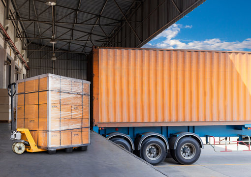 Packaging Boxes Stacked on Pallets Load with Shipping Cargo Container. Delivery Trucks Loading at Dock Warehouse. Supply Chain. Shipment Boxes. Distribution Warehouse Freight Truck Transport Logistics
