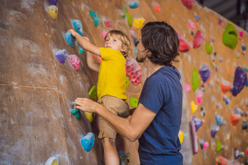 Dad and son at the climbing wall. Family sport, healthy lifestyle, happy family