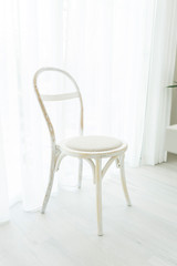Vintage wood chair by the window with white curtain. 