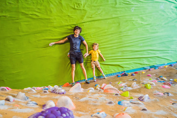 Dad and son at the climbing wall. Family sport, healthy lifestyle, happy family