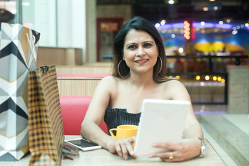 Fototapeta premium Woman drinking coffee and using mobile phone at cafe