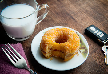 Tasty  fluffy yeast doughnuts or sugared donut  on white  plate and glass of milk on wood table, Best Morning recipe. 