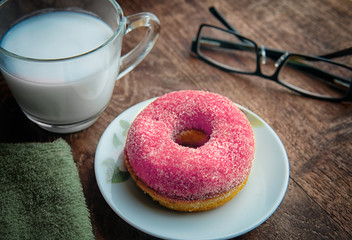 Tasty  fluffy yeast doughnuts or sugared donut  on white  plate and glass of milk on wood table, Best Morning recipe. 