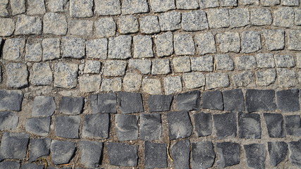 Texture road surface made of natural stone black and gray cobblestones