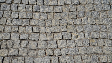 Texture road surface made of natural stone gray cobblestones