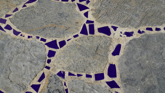 textured road made of natural stone and pieces of decorative tiles