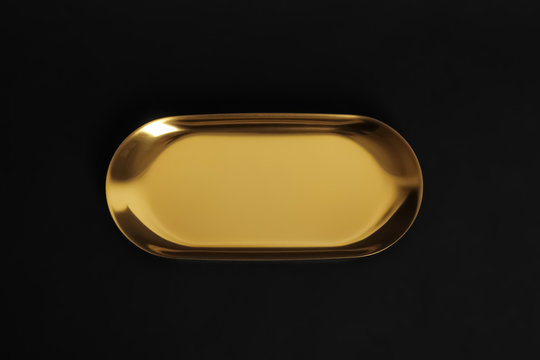 Luxury gold metal tray on black background, top view