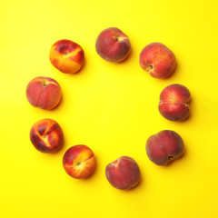 Flat lay composition with ripe peaches on yellow background, space for text