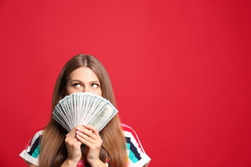 Portrait of thoughtful lottery winner with money on red background, space for text