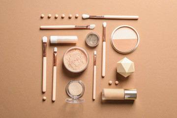 Flat lay composition with makeup brushes on brown background