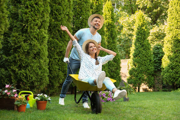 Happy couple having fun while working together in garden
