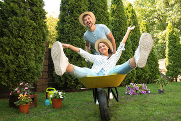 Happy couple having fun while working together in garden