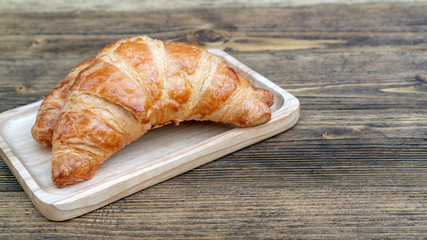 Croissant on a wooden table.