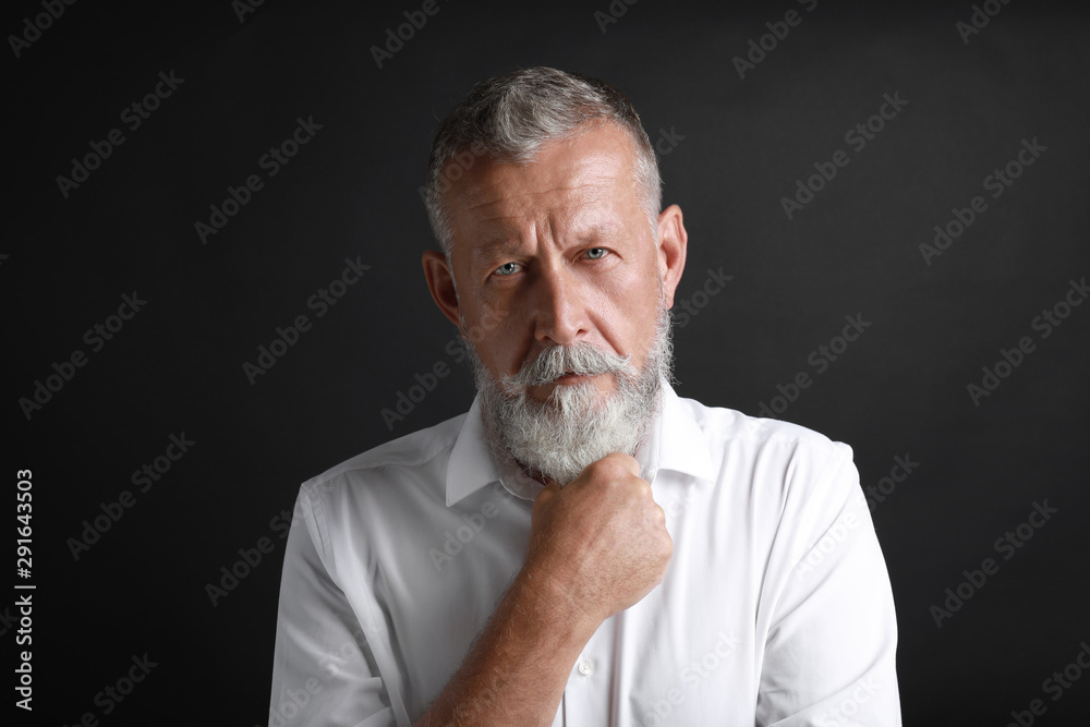 Wall mural Portrait of handsome senior man on black background