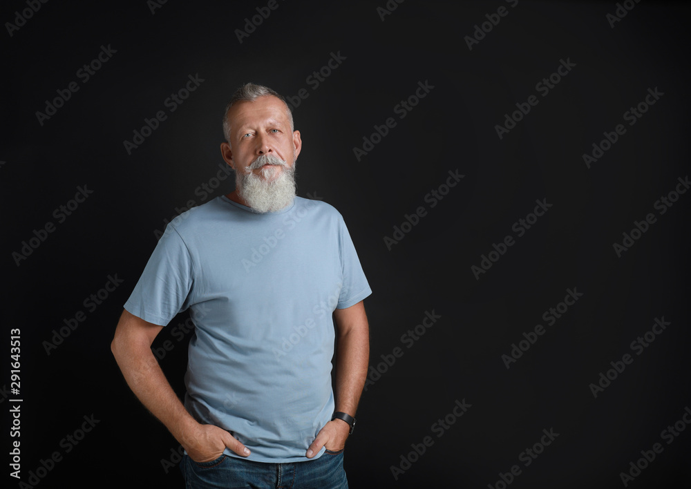 Wall mural Portrait of handsome senior man on black background