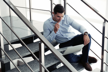 Portrait of young man with laptop indoors