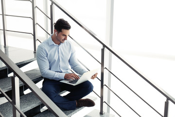 Portrait of young man with laptop indoors