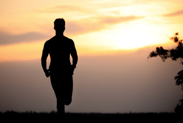 Young man running outdoors in evening. Space for text