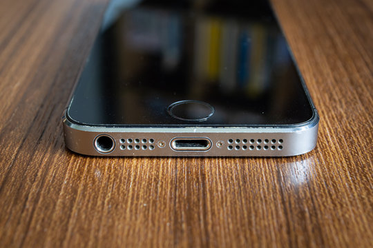 Bangkok, Thailand - June 1, 2019 : Bottom view of Apple iPhone 5s with 3.5mm headphone jack and Lightning connector.