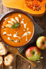 apples pumpkin puree soup served with toasted bread closeup. Vertical top view