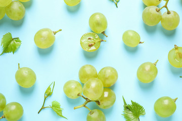Flat lay composition with fresh ripe juicy grapes on light blue background - obrazy, fototapety, plakaty