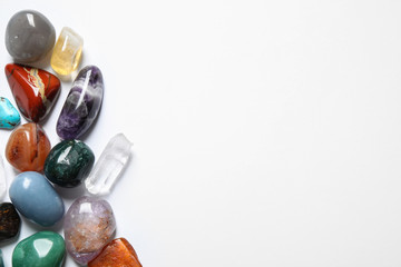Different beautiful gemstones on white background, top view