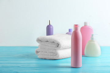 Toiletries and folded towels on light blue wooden table