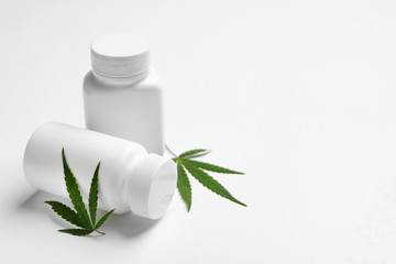 Hemp leaves and pill bottles on white background. Space for text