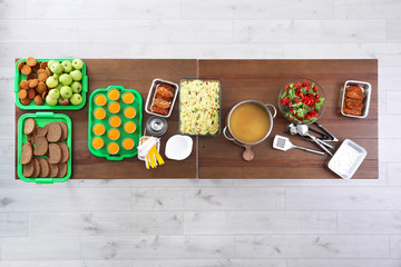 Wooden table with food to poor people in charity centre, top view