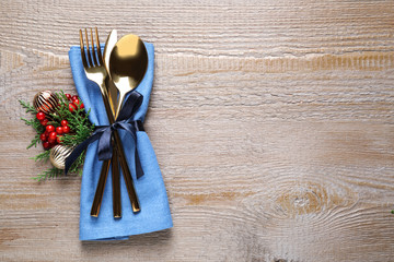 Cutlery set on wooden table, top view with space for text. Christmas celebration