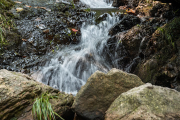 rushing down waterfall blocked by big rocks inside park under the shade
