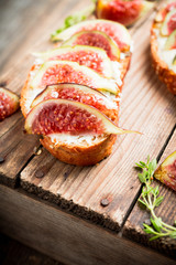 Sandwich with figs, cheese, honey and thyme. Selective focus. Shallow depth of field.