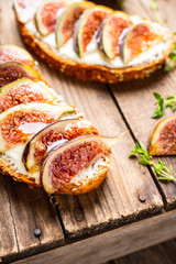 Sandwich with figs, cheese, honey and thyme. Selective focus. Shallow depth of field.
