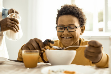 Obraz na płótnie Canvas Kid with glasses pretending to feed the toy.