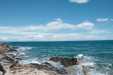 Fototapeta na wymiar Sea on a background of cloudy sky. Waves breaking on coastal cliffs