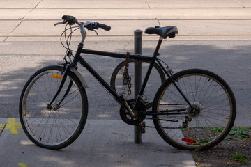 Fototapeta na wymiar old bicycle locked to a pole