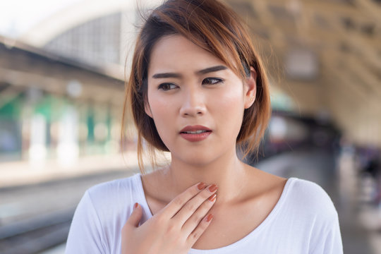 sick woman with sore throat portrait; sick asian woman with sore throat, cold, flu, contagious disease, health care concept; young adult asian woman model