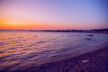 Obraz premium Greek Republic. Sunshine in sea and swimming people. In the distance mountains and sky. 17. Sep. 2019.