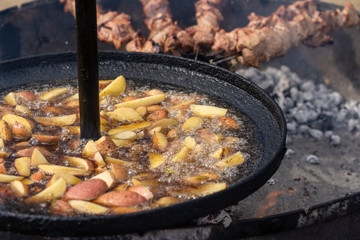 Roast potatoes in a large pan.Young potatoes are fried in oil, street food