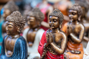Buddha statue figures souvenir on display for sale on street market in Bali, Indonesia. Handicrafts and souvenir shop display, close up