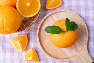 Sliced orange fruit on pink tablecloth texture background