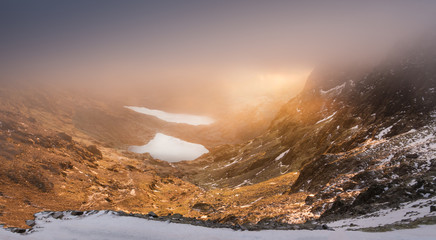 Snowdonia sunrise shot down a Welsh valley beneath thick cloud